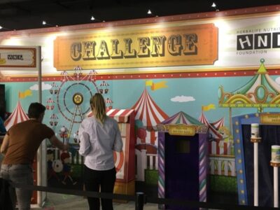 A group of people standing in front of a carnival booth.