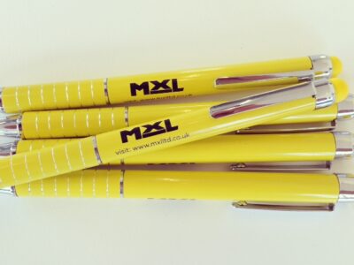 A group of yellow pens on a white surface.
